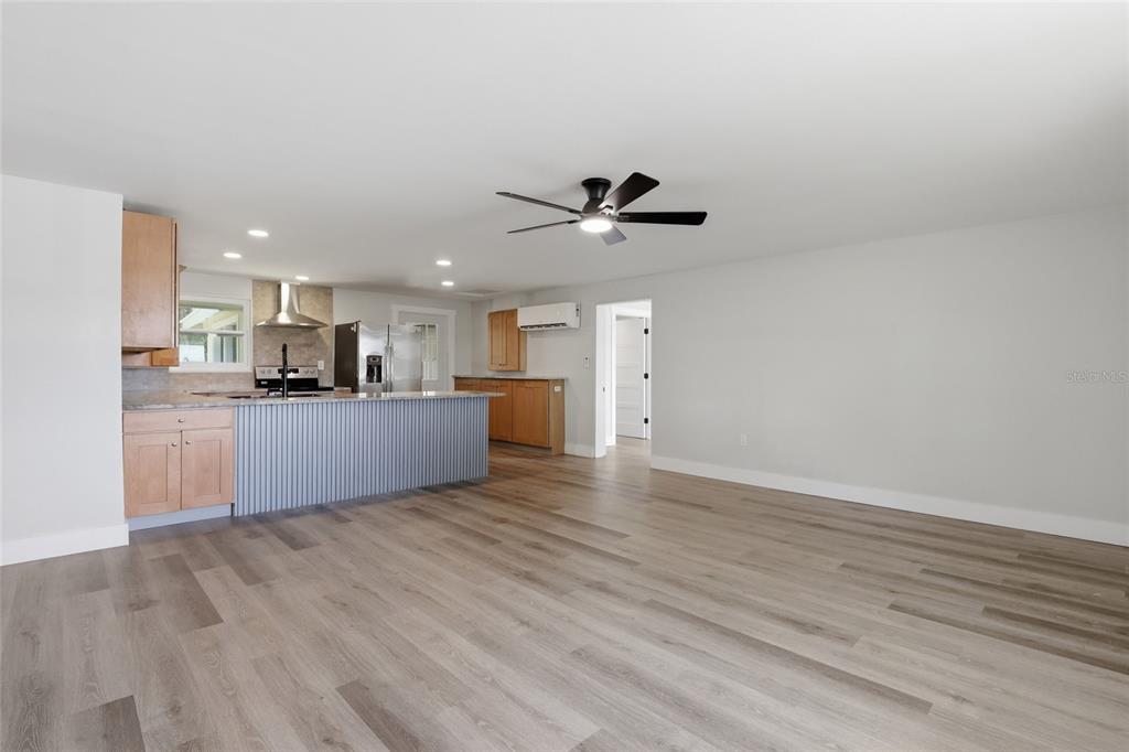 A kitchen with light wood cabinets and a corrugated metal island opens to a living area — 5587 SW HIGHWAY 17, ARCADIA, FL