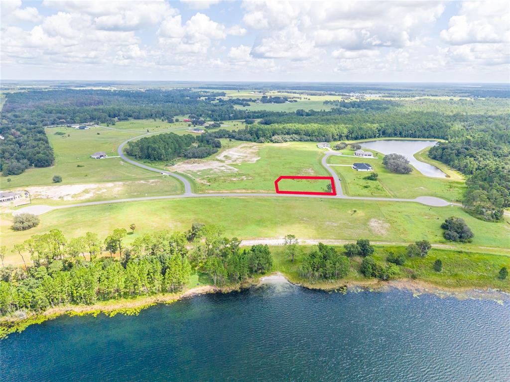 An aerial view shows a rectangular plot of land outlined in red near a lake — 38345 LAKE MEADOW COURT, UMATILLA, FL