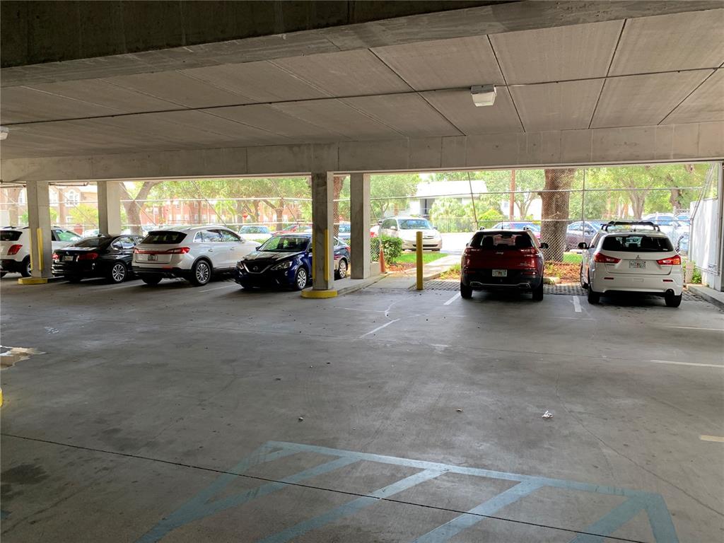 A multi-story tan apartment building features balconies, a tiled roof, and a corner entrance — 2111 W SWANN AVENUE, TAMPA, FL