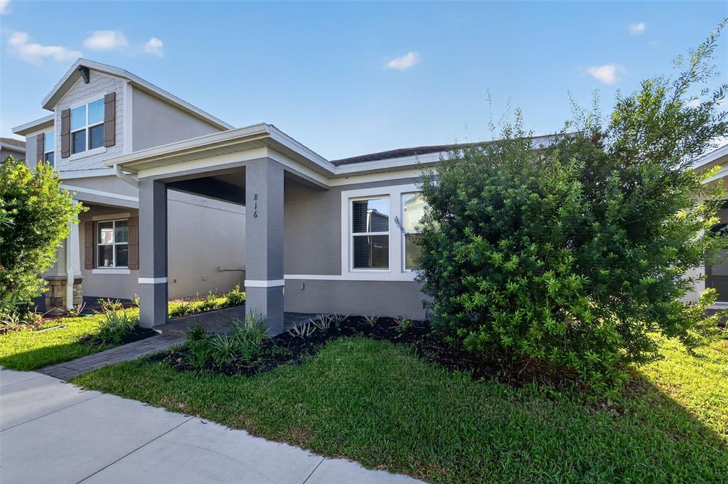 A gray two-story house with a covered entryway, a front lawn, and a large bush — 816 MIDDLETON STREET, DEBARY, FL