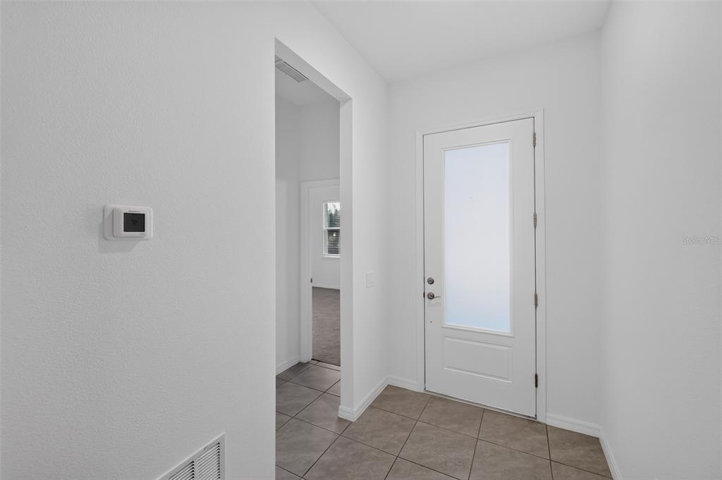 An entryway features a white front door with a frosted glass panel and tiled flooring — 816 MIDDLETON STREET, DEBARY, FL