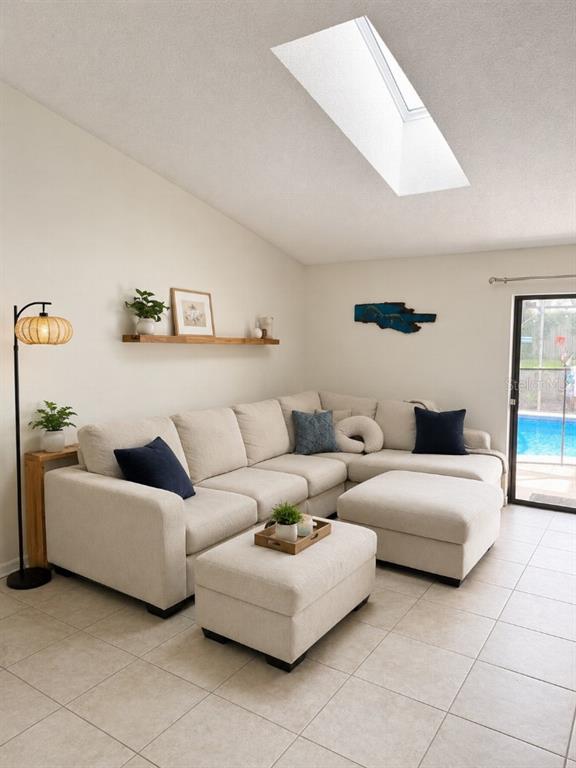 A living room features a beige sectional sofa, a skylight, and a sliding glass door — 1348 WINTERVILLE STREET, DELTONA, FL