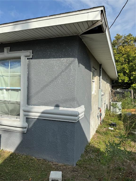 An exterior view of a gray stucco house corner with white trim and a soffit — 313 E WASHINGTON STREET, AVON PARK, FL