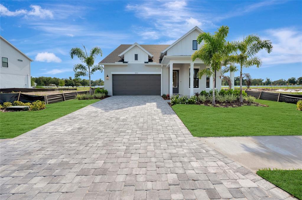 A single-story house with a paved driveway, a two-car garage, and palm trees — 6821 CHLOE COURT, SARASOTA, FL