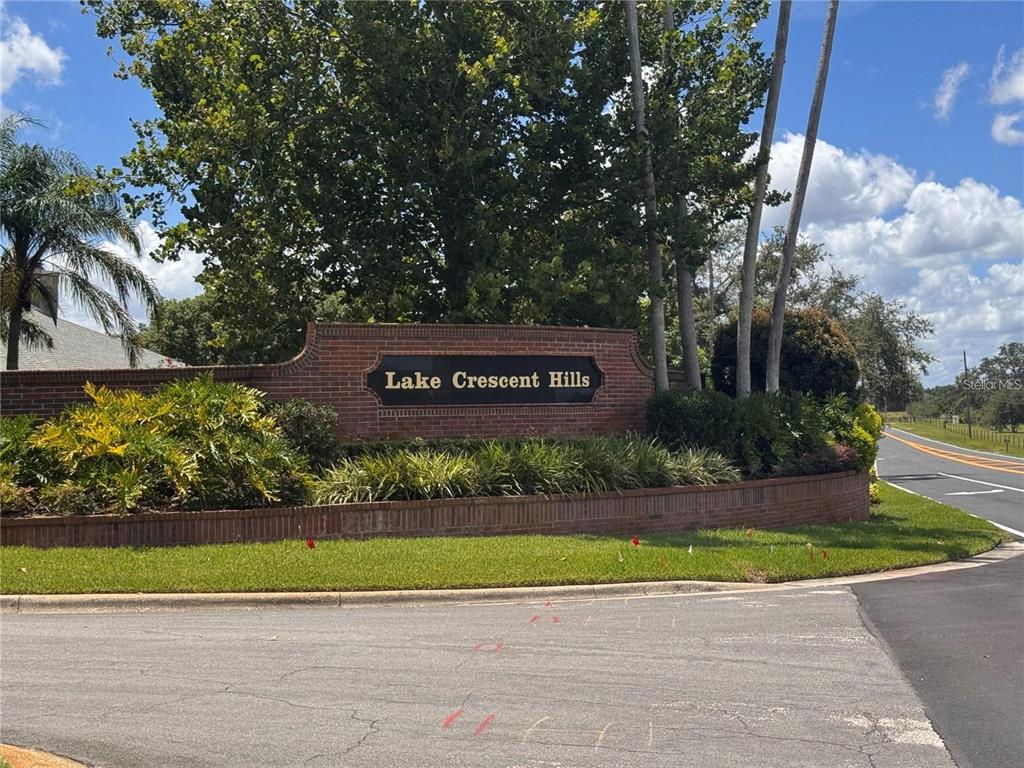 A brick monument sign for Lake Crescent Hills stands at a road intersection — 10642 CRESCENT LAKE COURT, CLERMONT, FL