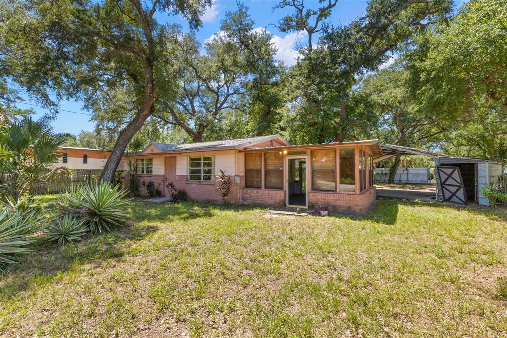 A single-story house with a brick base, light-colored siding, and an attached carport and shed — 6903 OHIO AVENUE, GIBSONTON, FL