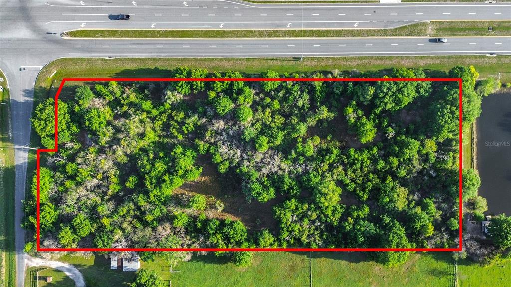 An aerial view shows a rectangular, tree-covered plot of land outlined in red — 0000 OLD HICKORY TREE ROAD, ST CLOUD, FL