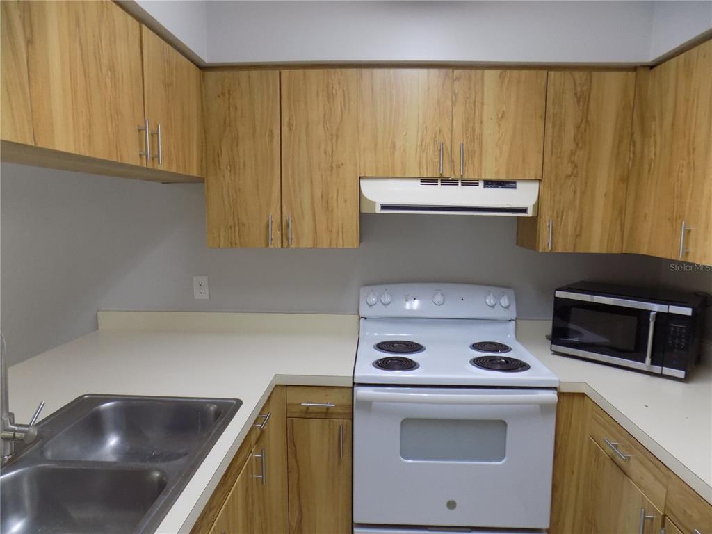 The exterior of a two-story townhouse features a screened patio, two air conditioning units, and a satellite dish — 2735 SW 35TH PLACE UNIT 1801, GAINESVILLE, FL