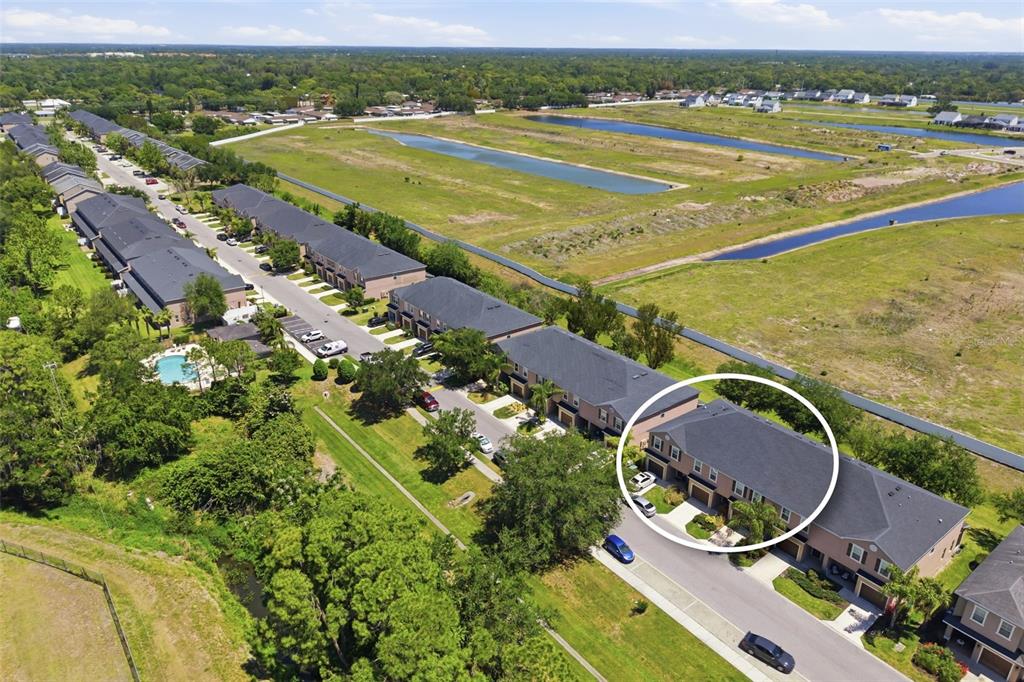 An aerial view shows a residential street with townhomes, including one circled in white — 1306 GRANTHAM DRIVE, SARASOTA, FL