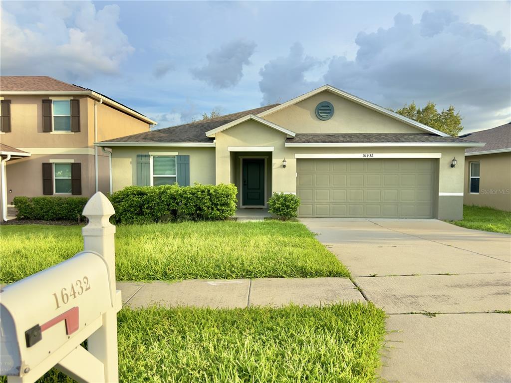 A single-story house with a green exterior, a two-car garage, and a white mailbox — 16432 CAJU ROAD, CLERMONT, FL
