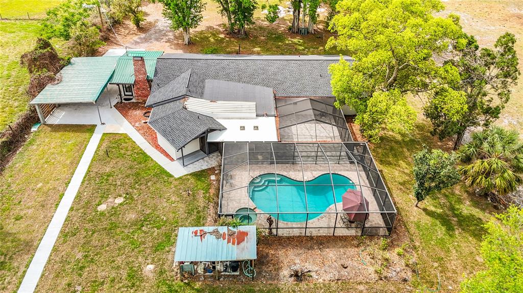 An aerial view of a single-story house with a screened pool and a large yard — 216 CORBETT ROAD, LITHIA, FL