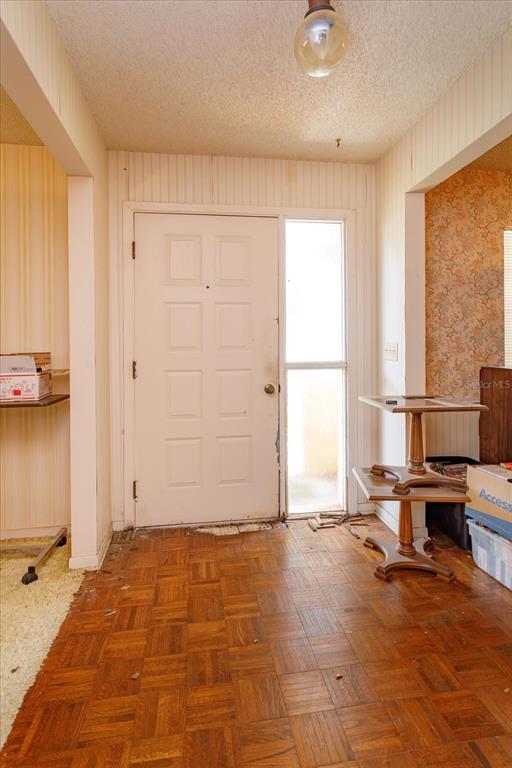 An entryway features a white paneled front door, parquet wood flooring, and a small side table — 1016 CATHY DRIVE, ALTAMONTE SPRINGS, FL