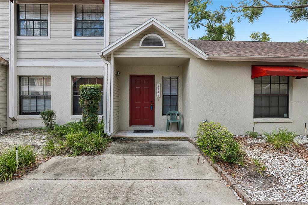 An entryway features a white front door, beige walls, and a tiled floor — 8419 LAURELON PLACE, TEMPLE TERRACE, FL