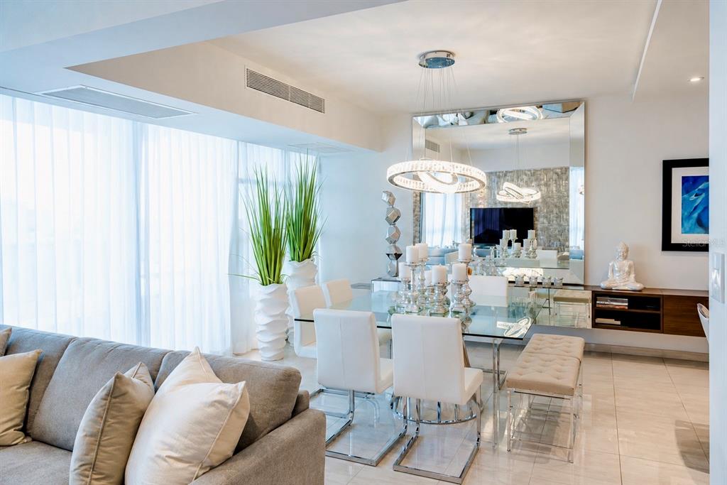 A modern dining area features a glass table, white chairs, and a large wall mirror — 405 COND. MIRADOR DEL PARQUE UNIT 904, SAN JUAN, PR