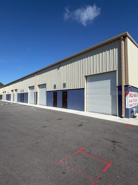 A spacious warehouse interior features a concrete floor, metal ceiling, and a pallet of drums — 2835 HAMMOND ROAD, FORT PIERCE, FL