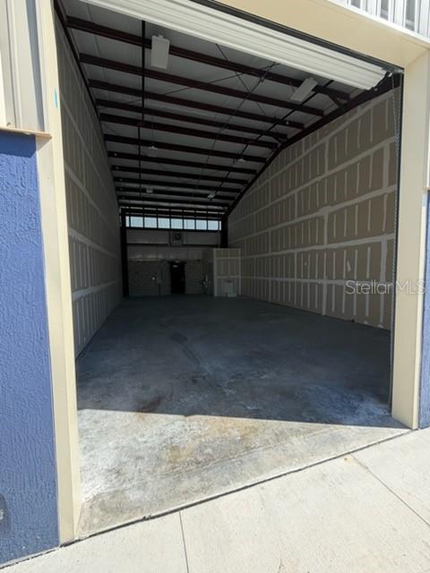 An exterior view of a long industrial warehouse building with multiple roll-up bay doors — 2835 HAMMOND ROAD, FORT PIERCE, FL