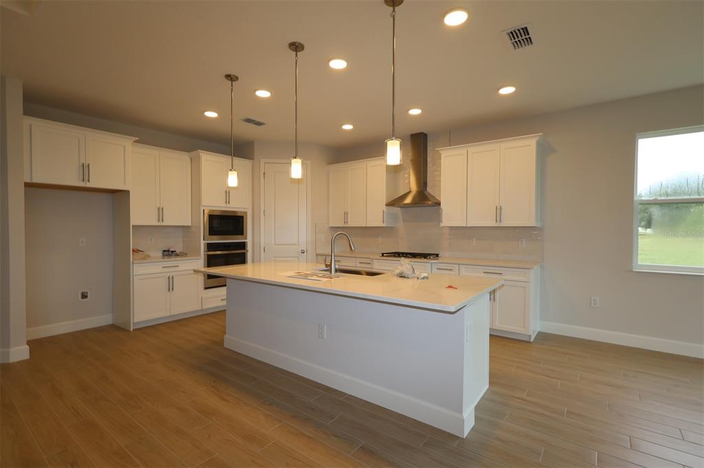 An unfinished room features concrete block walls with wood furring strips and exposed roof trusses — 3722 WOLVES CREEK PLACE, APOPKA, FL