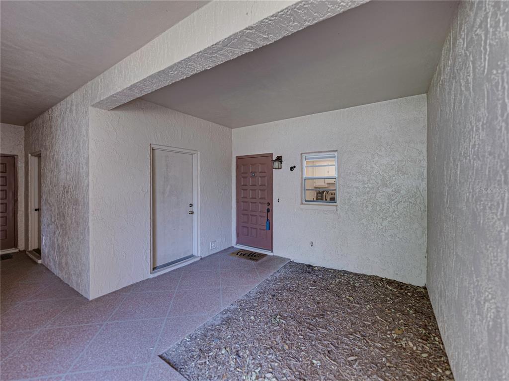A two-story apartment building features stucco walls, a red tile roof, and arched entryways — 9700 STARKEY ROAD UNIT 312, SEMINOLE, FL