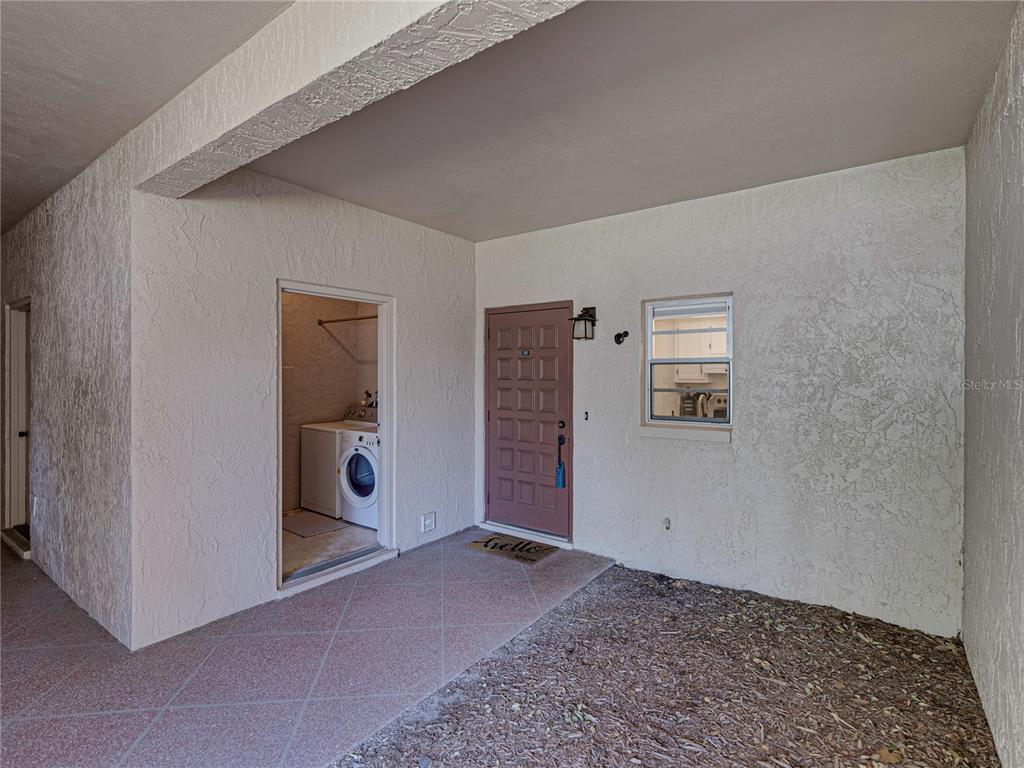 A two-story apartment building features arched entryways, balconies, and a paved parking space — 9700 STARKEY ROAD UNIT 312, SEMINOLE, FL