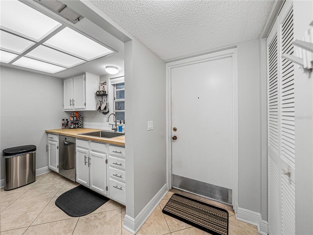 An exterior entryway features a brown door, a laundry closet, and a window — 9700 STARKEY ROAD UNIT 312, SEMINOLE, FL