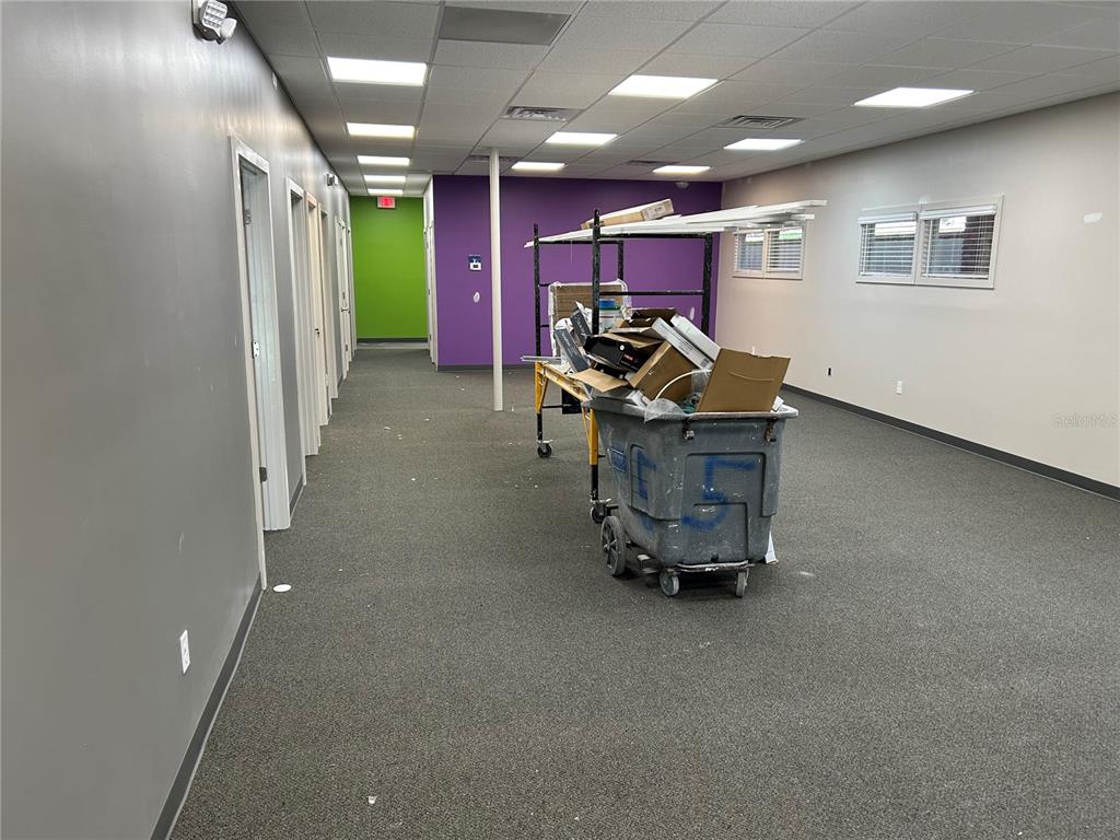 An office hallway features gray walls, a purple accent wall, and a rolling utility cart — 2100 SE 17TH STREET UNIT 902, OCALA, FL