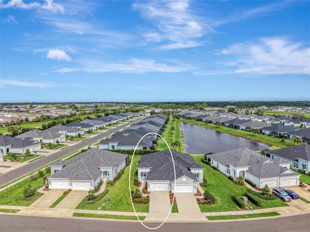 An aerial view shows a residential street with a circled duplex home and a pond — 4842 WILLOW BEND AVENUE, PARRISH, FL