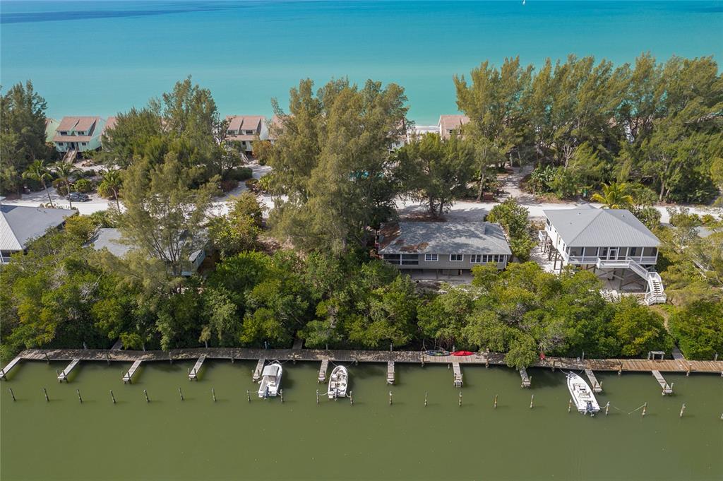 An aerial view shows waterfront houses with private docks along a canal near the ocean — 322 S GULF BOULEVARD, PLACIDA, FL