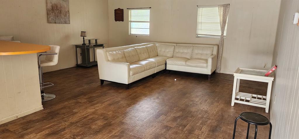 A living room features a white sectional sofa, wood-look flooring, and a breakfast bar — 1821 LOS PINOS ROAD, ARCADIA, FL