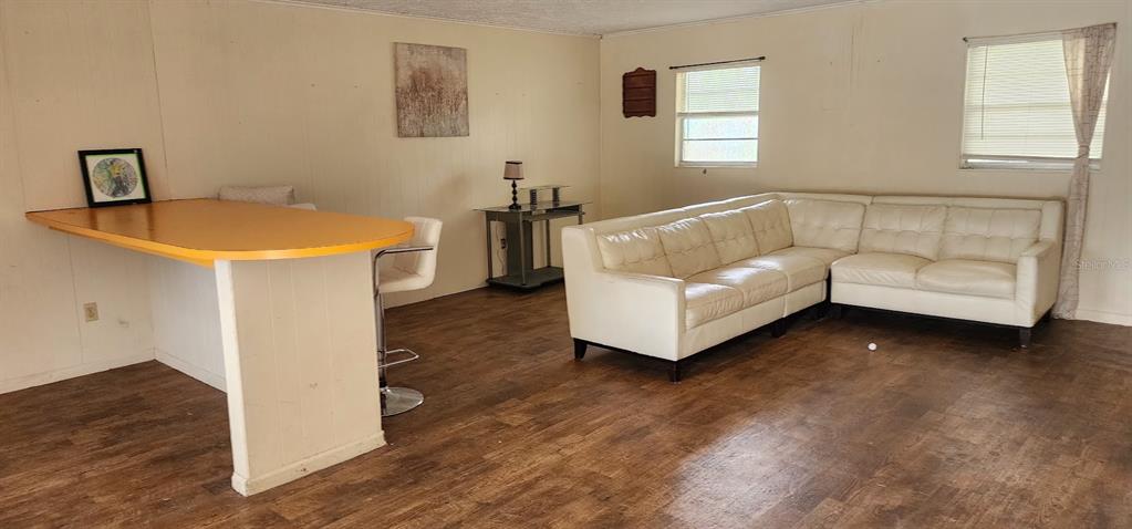 A living room features wood-look flooring, a white sectional sofa, and a yellow breakfast bar — 1821 LOS PINOS ROAD, ARCADIA, FL