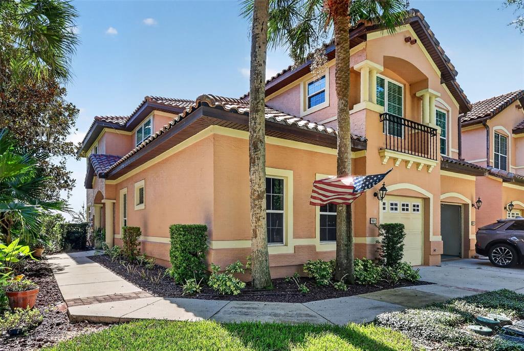 A two-story peach-colored house with a tile roof, a garage, and a small balcony — 901 CAMINO REAL BOULEVARD UNIT 901, HOWEY IN THE HILLS, FL