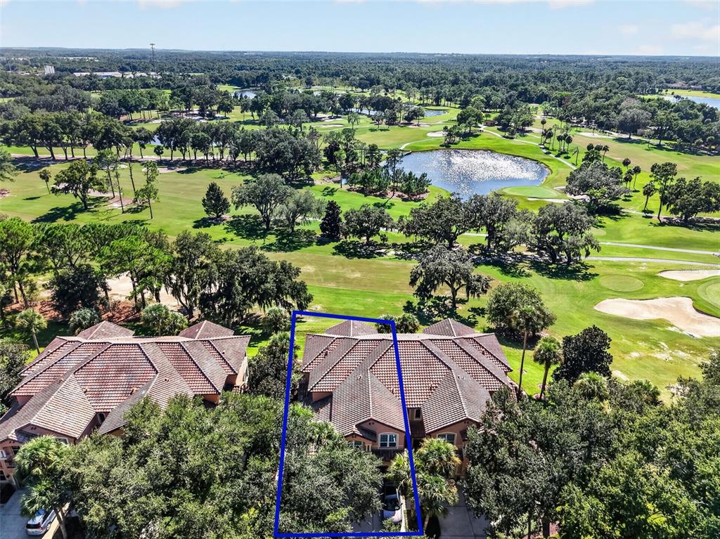 An aerial view shows a residential building with a tiled roof overlooking a golf course — 901 CAMINO REAL BOULEVARD UNIT 901, HOWEY IN THE HILLS, FL