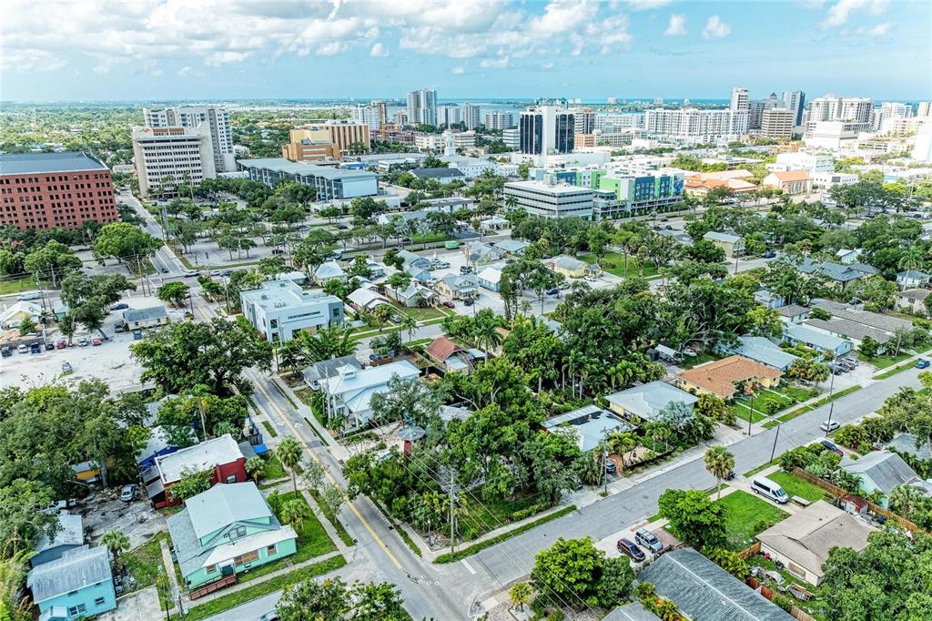 An aerial view shows a residential neighborhood with houses, trees, and a distant city skyline — 449 N OSPREY AVENUE, SARASOTA, FL