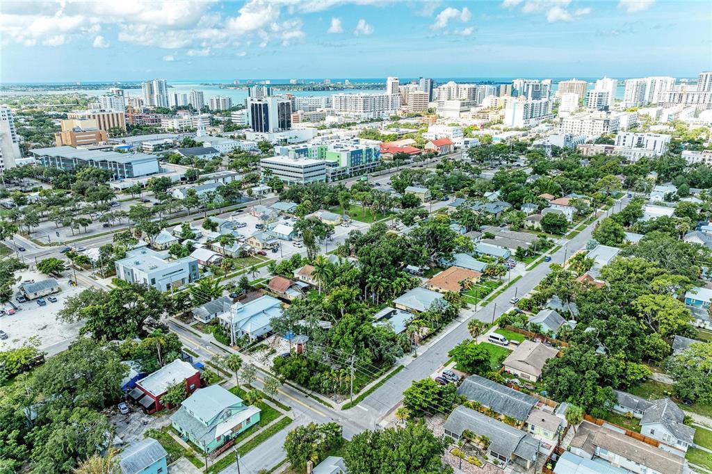 An aerial view of a residential neighborhood with houses, trees, and a distant city skyline — 449 N OSPREY AVENUE, SARASOTA, FL