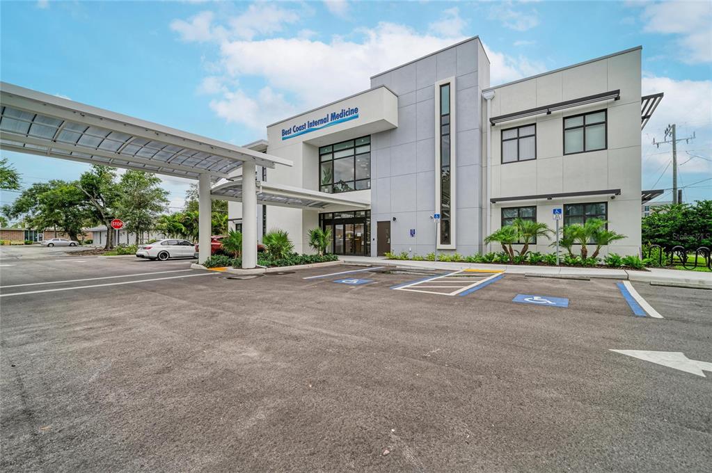 A modern medical office building exterior with a covered drop-off area and handicap parking spaces — 201 5TH AVENUE DRIVE E, BRADENTON, FL