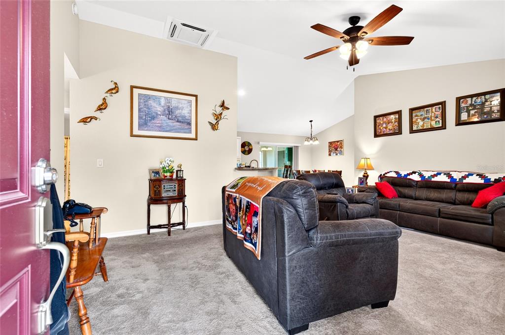 A single-story house with a beige stucco exterior, a two-car garage, and an American flag — 13581 SW 48TH COURT, OCALA, FL