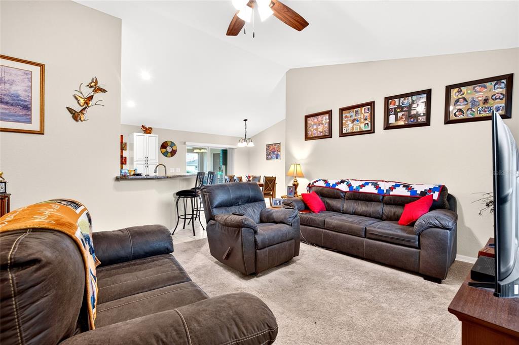 A single-story house with a beige stucco exterior, a dark roof, and a two-car garage — 13581 SW 48TH COURT, OCALA, FL