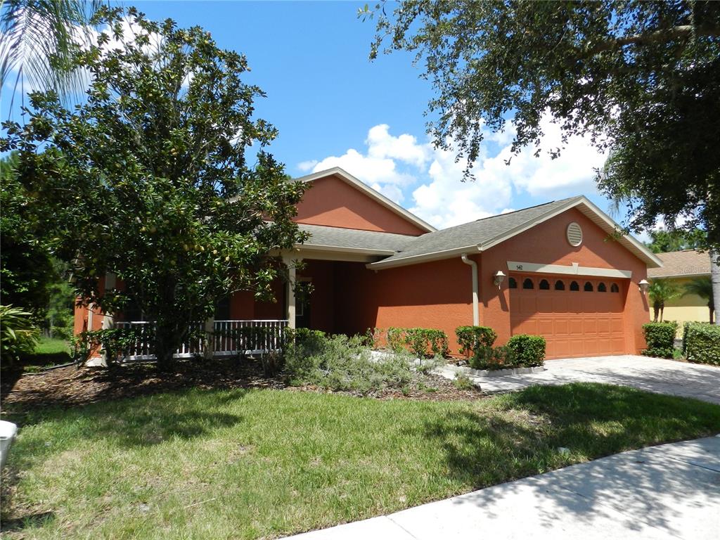 A single-story orange stucco house with a two-car garage and a front porch — 542 PORTOFINO DRIVE, POINCIANA, FL