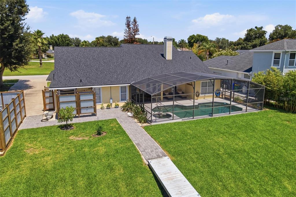 An aerial view of a house with a screened-in pool, patio, and large grassy backyard — 3716 BAYSHORE CIRCLE, TAVARES, FL