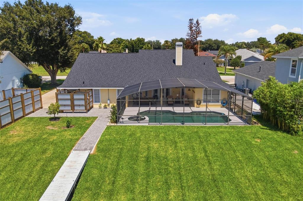 An aerial view of a house with a screened-in pool, patio, and a grassy backyard — 3716 BAYSHORE CIRCLE, TAVARES, FL