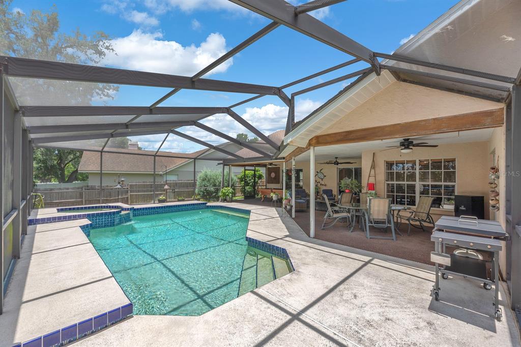A foyer with a round floral rug leads into a dining area with wood flooring — 621 PENN NATIONAL ROAD, SEFFNER, FL