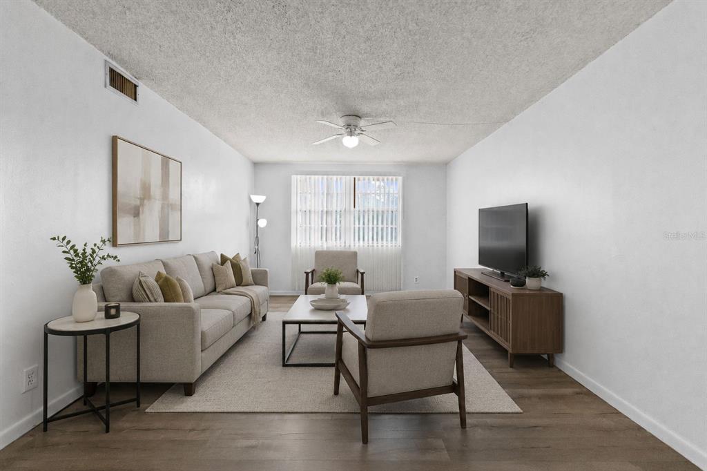 A living room features a sofa, two armchairs, a coffee table, and a television console — 5820 N CHURCH AVENUE UNIT 345A, TAMPA, FL