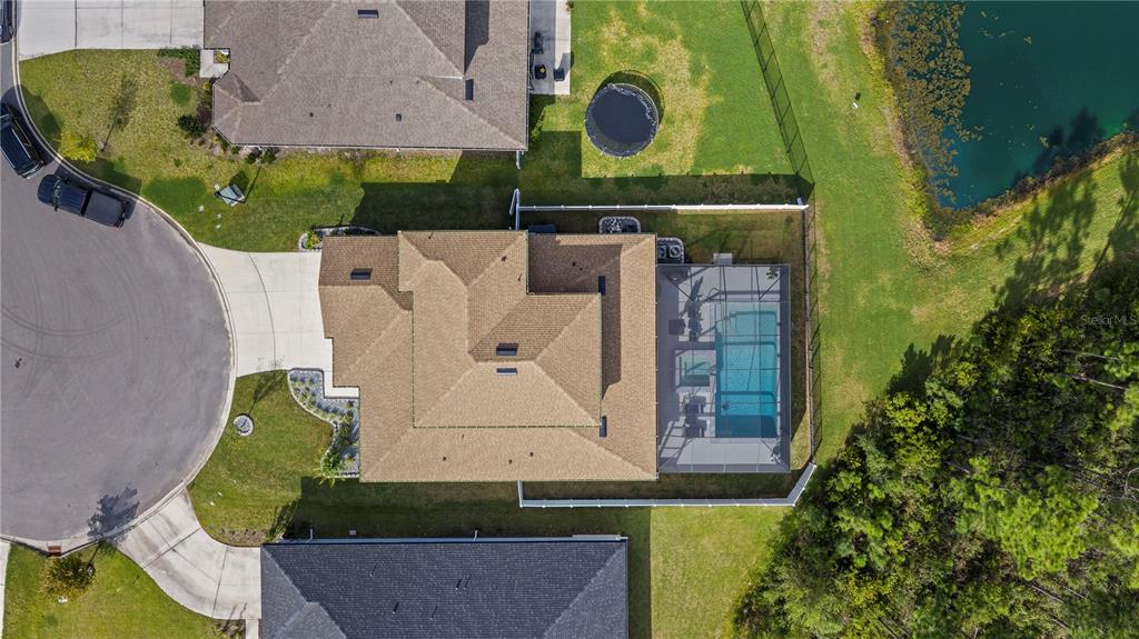 An aerial view shows a house with a shingled roof, pool enclosure, and fenced backyard — 2453 GLADE LANE, GREEN COVE SPRINGS, FL