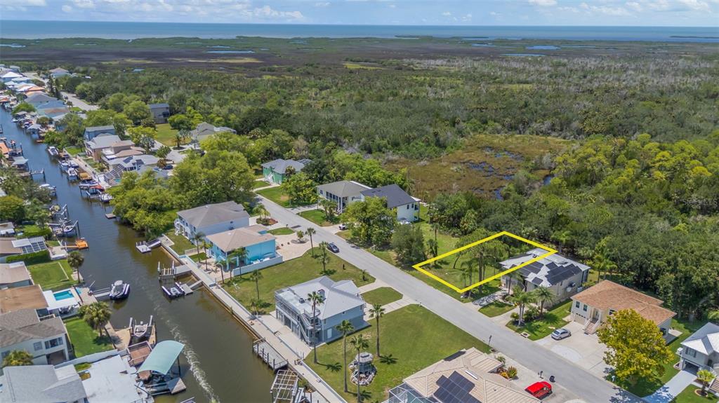 An aerial view shows a residential street with a vacant lot highlighted in yellow — GULF WAY, HUDSON, FL