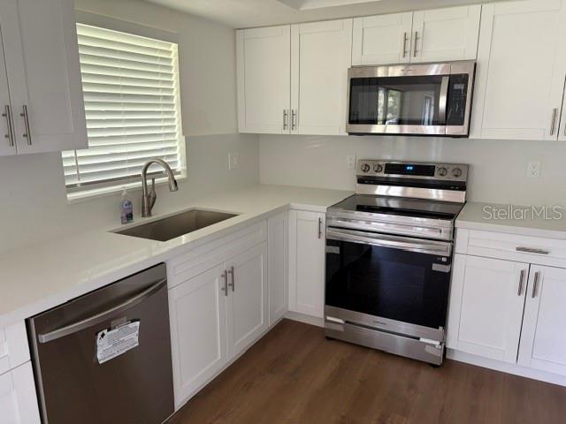 An empty room with wood-look flooring, white walls, a ceiling fan, and a sliding glass door — 8985 SW 196TH TERRACE ROAD, DUNNELLON, FL