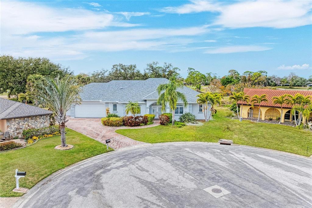 A single-story house with a gray roof and a brick driveway sits on a cul-de-sac — 4540 KIPLING CIRCLE, SARASOTA, FL