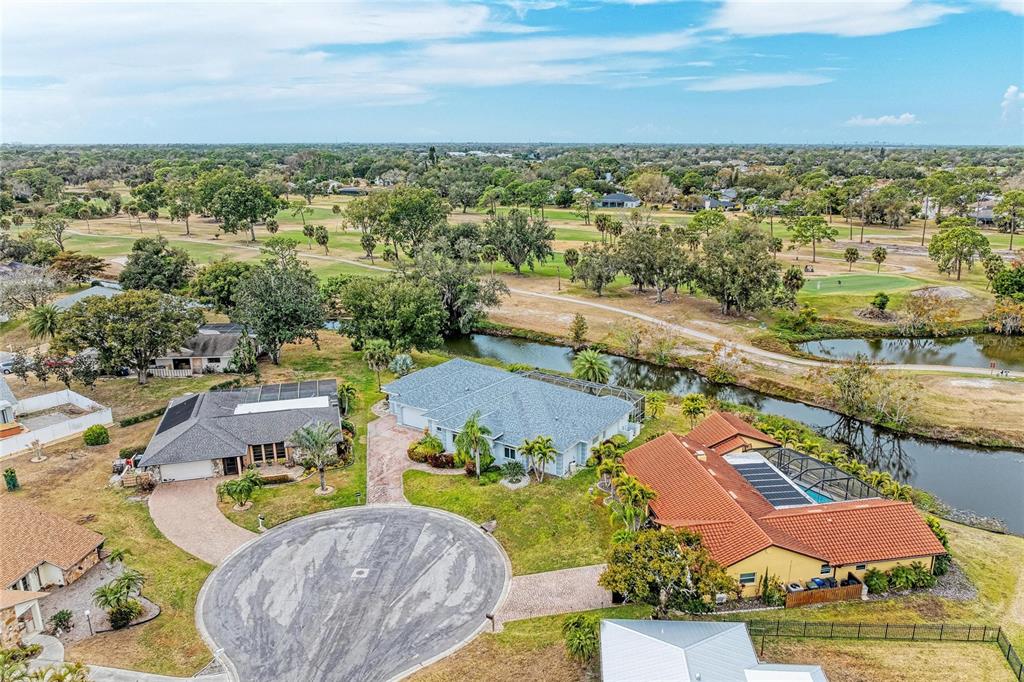 An aerial view shows three houses situated along a cul-de-sac next to a golf course — 4540 KIPLING CIRCLE, SARASOTA, FL