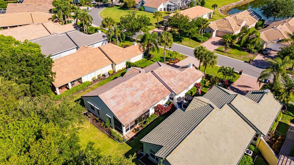 An aerial view shows several suburban houses with tiled roofs and surrounding trees and lawns — 2305 SUMMERSWEET DRIVE, ALVA, FL
