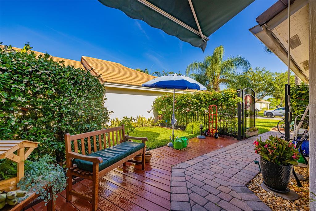 A wooden bench sits on a deck next to a brick walkway and a small lawn — 2305 SUMMERSWEET DRIVE, ALVA, FL