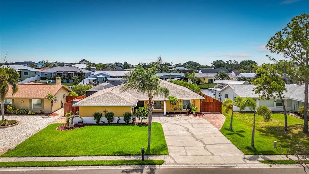 An aerial view of a yellow single-story house with a driveway and front lawn — 6517 SOLITAIRE PALM WAY, APOLLO BEACH, FL