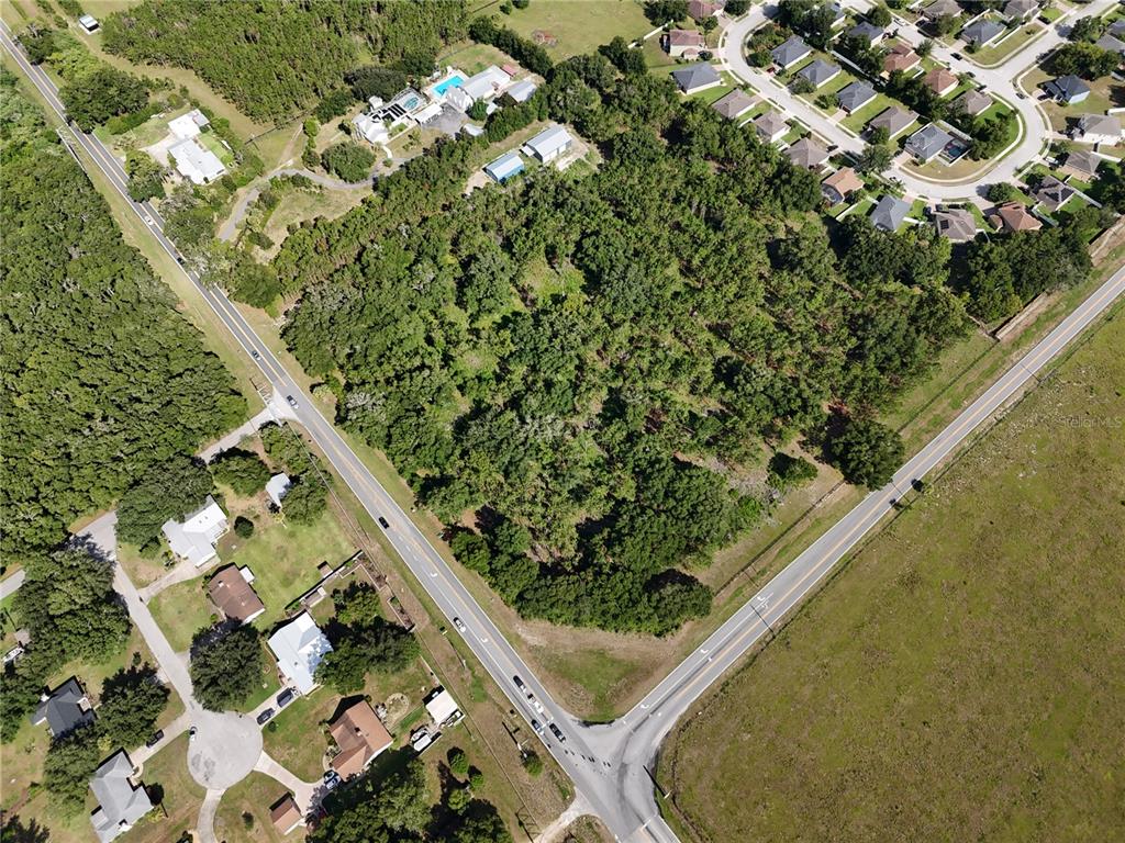 An aerial view shows a wooded lot situated at the intersection of two roads — 00 E COUNTY ROAD 44A, EUSTIS, FL